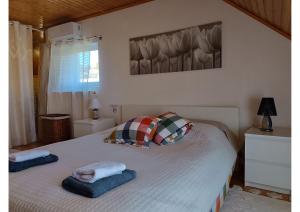 a bedroom with a bed with two pillows on it at Grand Chalet Cottage House in Porto Rafti