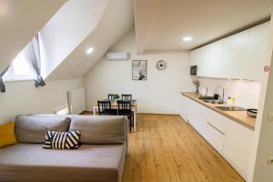 a living room with a couch and a kitchen at Flexible SelfCheckIns 71 - Zagreb - New - Center - 50m from the Main Square in Zagreb