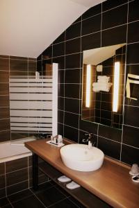 La salle de bains est pourvue d'un lavabo et d'un miroir. dans l'établissement Thalasso Concarneau Spa Marin Resort, à Concarneau