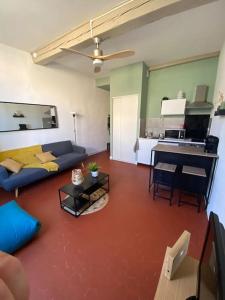 a living room with a couch and a table at Le For’Home in Arles +20 photos