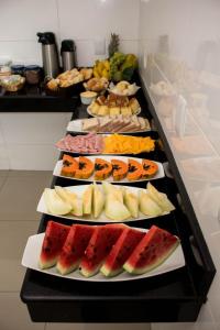 a buffet line with different types of fruit on plates at Hotel Aliança in Salvador