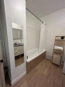 a white bathroom with a tub and a sink at Le For’Home in Arles