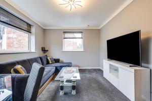 a living room with a couch and a flat screen tv at Lavish 2BR Bungalow Retreat in Birkenhead in Birkenhead