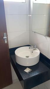 lavabo blanco en el baño con espejo en Hotel Aliança, en Salvador