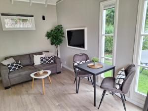 sala de estar con sofá y mesa en Park De Driesprong, en Nieuwveen