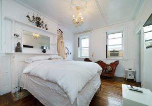 biała sypialnia z dużym łóżkiem i żyrandolem w obiekcie Lovely 1BR Apartment in Prime Location w Nowym Jorku