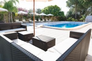 a swimming pool with chairs and a table and an umbrella at Hotel Villa Costes in Gallipoli
