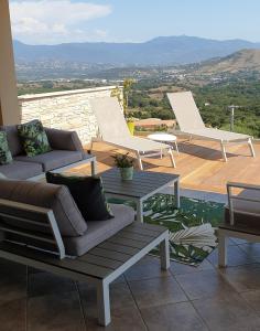 een patio met 2 ligstoelen en een tafel bij Villa Standing - Piscine et Vue Mer in Alata