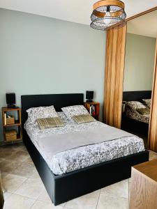 een slaapkamer met een groot bed met een zwart frame bij Villa Standing - Piscine et Vue Mer in Alata