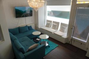 ein Wohnzimmer mit einem blauen Sofa und einem Fenster in der Unterkunft City-Apartment II Kreuzberg in Berlin