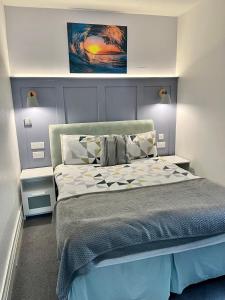 um quarto com uma cama e um quadro na parede em Beaconsfield Holiday Apartments em Bridlington