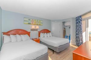 a hotel room with two beds and a desk at Newly Renovated 1 Bedroom Condo- Oceanfront Views! Boardwalk 1139 in Myrtle Beach +37 photos