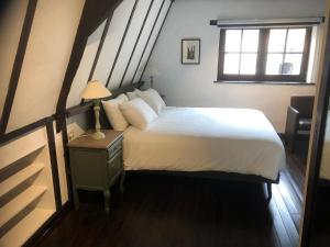 een slaapkamer met een groot bed en een raam bij De Pelgrim in Tongeren