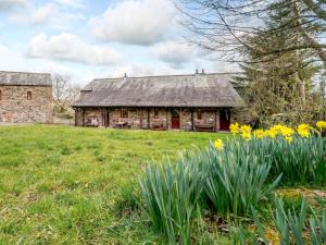 an old stone barn with daffodils in front of it at 3 Bed in Watermillock SZ318 in Watermillock