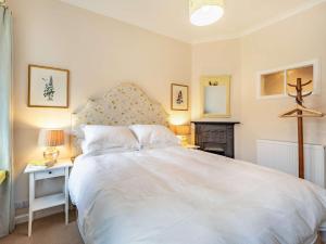 a bedroom with a large white bed and a fireplace at 2 bed property in Kelso 86452 in Birgham