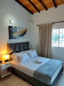 a bedroom with a large bed with white sheets at ApartaHostal Quintanilla in Villanueva