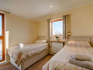 a bedroom with two beds and two windows at 2 Bed in Sowerby Bridge 90887 in Sowerby Bridge