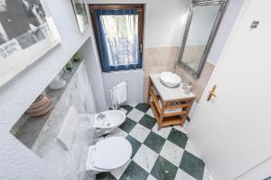 a bathroom with a toilet and a sink and a mirror at DiVino Holiday Apartments in Alba