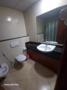a bathroom with a sink and a toilet and a mirror at Tide Private Couples Room 7 min from Mall of Emirates in Dubai