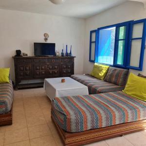 ein Wohnzimmer mit 2 Sofas und einem TV in der Unterkunft Maisonnette vue mer en pleine campagne. Originale. in El Jadida