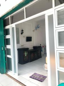 an open sliding glass door to a room with a television at Minamo Homestay Modern Tengah Kota Payakumbuh in Payakumbuh