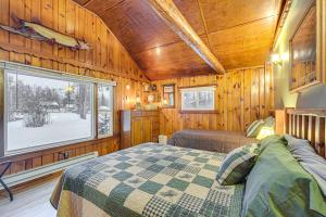 a bedroom with a bed and a window in a cabin at Hayward Retreat on the Chippewa Flowage with Dock! in New Post