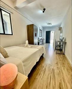 um quarto com uma cama e uma sala de estar em Apartamentos - Estúdios em São José