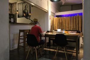 a man sitting at a table in a room at The Patio Yogya in Yogyakarta