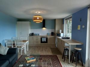 a kitchen and living room with a couch and a table at La Petite Maison à Vieillecour in Saint-Pierre-de-Frugie