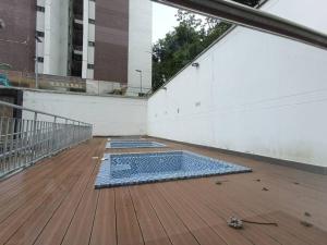 uma piscina numa varanda com um deque de madeira em Atractivo Apartaestudio Conj Res em Floridablanca