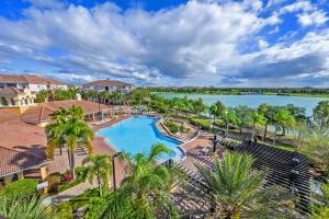 an aerial view of a pool at a resort with a lake at Beautiful Townhome, Vista Cay Resort Direct - 4010 in Orlando