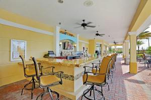 a bar in a restaurant with chairs around it at Beautiful Townhome, Vista Cay Resort Direct - 4010 in Orlando