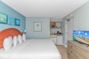 a bedroom with a bed and a flat screen tv at Newly Renovated King Suite-Ocean Views! Boardwalk 1140 in Myrtle Beach