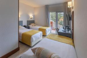 a hotel room with two beds and a balcony at Soho Boutique Los Naranjos in Málaga