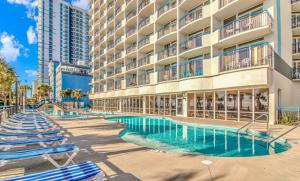 un hotel con tumbonas y piscina en Newly Renovated King Suite-Ocean Views! Boardwalk 1140, en Myrtle Beach