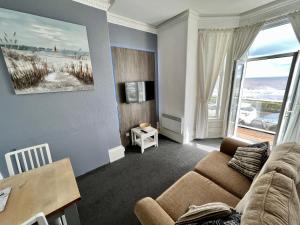 uma sala de estar com um sofá e uma grande janela em Beaconsfield Holiday Apartments em Bridlington