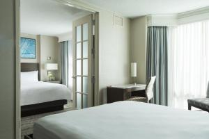 um quarto de hotel com uma cama e uma cadeira em Homewood Suites By Hilton Downers Grove Chicago, Il em Downers Grove