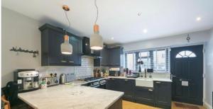 a kitchen with black cabinets and a counter top at Stylish Rental House SE16 in London