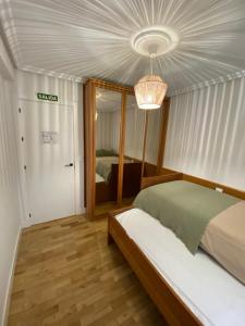 1 dormitorio con cama y lámpara de araña en Apartamento Zuhaitzondoa Etxea en Elizondo
