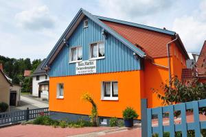 an orange and blue house with a blue roof at Haus Martin in Kurort Steinbach-Hallenberg