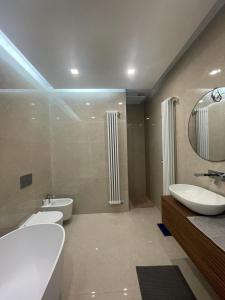 een badkamer met een wastafel, een toilet en een spiegel bij Angolo di isa in Busto Arsizio