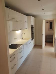 a kitchen with white cabinets and a sink and appliances at Spacious modern 3 bedroom aparment in Prague