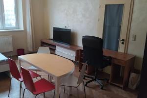 Zimmer mit einem Schreibtisch, einem Tisch und Stühlen in der Unterkunft Spacious modern 3 bedroom aparment in Prag