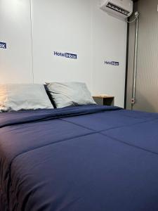 a blue bed in a room with two signs on the wall at Hotel In Box in Irati