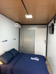 een slaapkamer met een blauw bed en een deur bij Hotel In Box in Irati