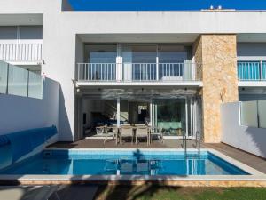 a house with a swimming pool in front of a house at Luxury House - Privat Heated Pool & Ecologic & BBQ & Privacy & Albufeira in Albufeira