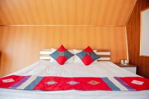 sypialnia z łóżkiem z czerwonymi i niebieskimi poduszkami w obiekcie Bungalow1982 w mieście Dồng Văn