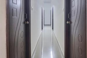 korytarz z drewnianymi drzwiami i długim korytarzem w obiekcie OYO 81751 Hotel SBR Kondapur Near RTO office w mieście Hajdarabad