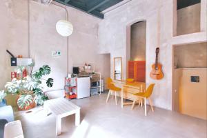 a living room with a table and chairs and a guitar at Estudio Loft en el centro de Madrid reformado en enero 2024 in Madrid