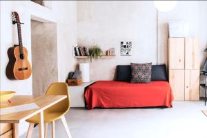 ein Schlafzimmer mit einem roten Bett und einer Gitarre in der Unterkunft Estudio Loft en el centro de Madrid reformado en enero 2024 in Madrid